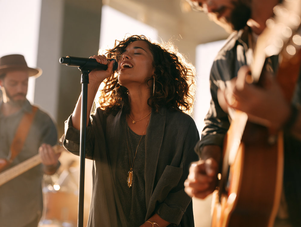 Female worship leader singing with worship team
